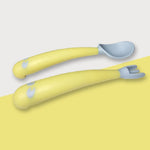 Bambino che impara a mangiare piegando la forchetta con il cucchiaio e il gomito