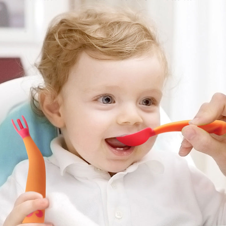 Bambino che impara a mangiare piegando la forchetta con il cucchiaio e il gomito