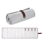 Borsa organizer arrotolabile in velluto per gioielli, con scomparti multipli per collane, bracciali e accessori in oro.