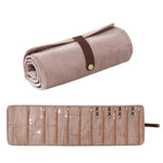 Borsa organizer arrotolabile in velluto per gioielli, con scomparti multipli per collane, bracciali e accessori in oro.
