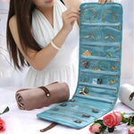 Borsa organizer arrotolabile in velluto per gioielli, con scomparti multipli per collane, bracciali e accessori in oro.