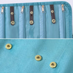 Borsa organizer arrotolabile in velluto per gioielli, con scomparti multipli per collane, bracciali e accessori in oro.