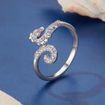 Anello regolabile con apertura a forma di cavalluccio marino, placcato rame e oro bianco.
